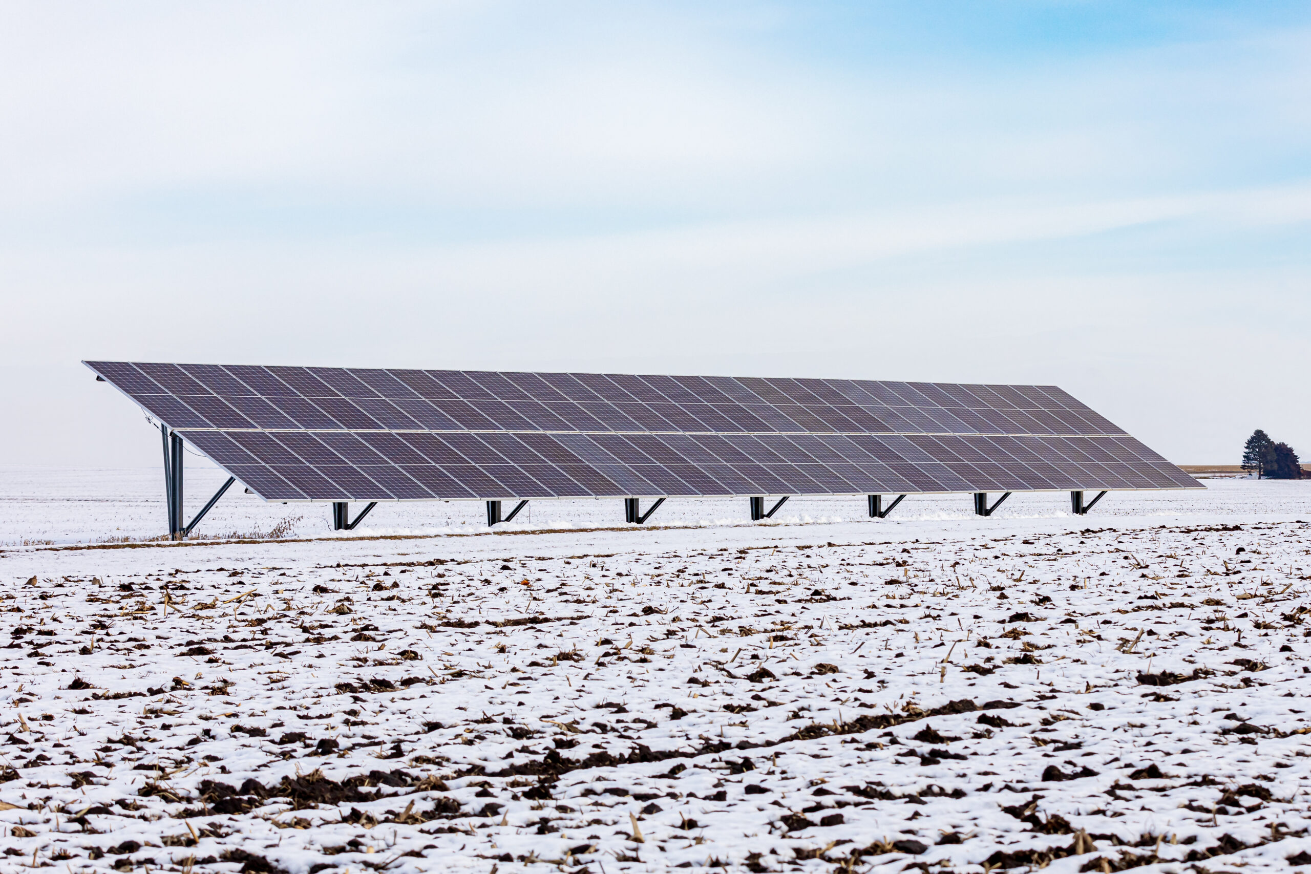 Ground mounted solar panels in snow covered farm field